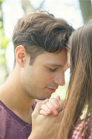simsearch:614-06896801,k - Couple touching foreheads and holding hands outdoors Stock Photo - Premium Royalty-Free, Code: 633-08151087