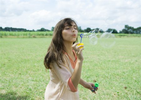 simsearch:632-05604245,k - Girl blowing bubbles outdoors Stock Photo - Premium Royalty-Free, Code: 633-01274353