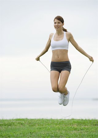 Young woman jumping rope by lakeside Stock Photo - Premium Royalty-Free, Code: 633-01272842