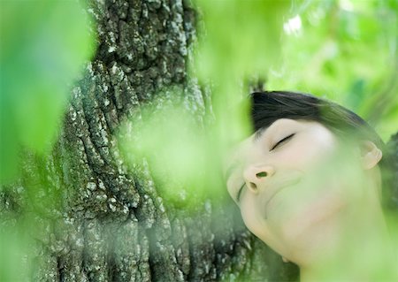 simsearch:633-01574151,k - Woman leaning against tree Stock Photo - Premium Royalty-Free, Code: 633-01272850