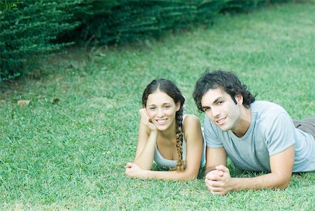 simsearch:633-01715612,k - Couple lying on grass, side by side, smiling at camera Stock Photo - Premium Royalty-Free, Code: 633-01574055