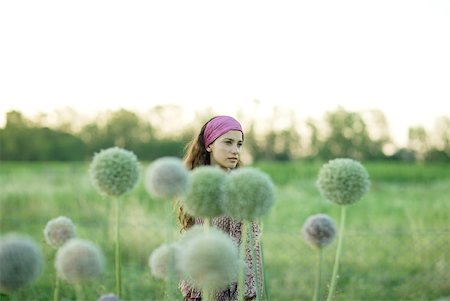 simsearch:859-03983201,k - Young woman standing in field, allium in foreground Stock Photo - Premium Royalty-Free, Code: 633-01574147