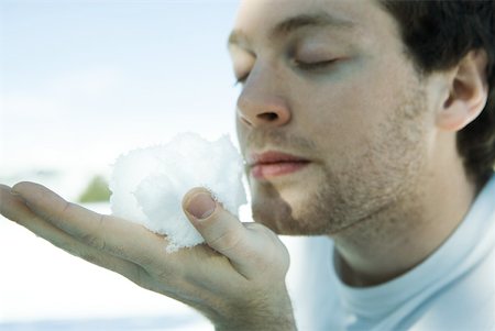 simsearch:633-01574151,k - Young man holding snow ball in hand, eyes closed Stock Photo - Premium Royalty-Free, Code: 633-01574544