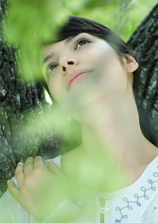 simsearch:633-01574151,k - Woman with head against tree trunk, looking up Stock Photo - Premium Royalty-Free, Code: 633-01572644