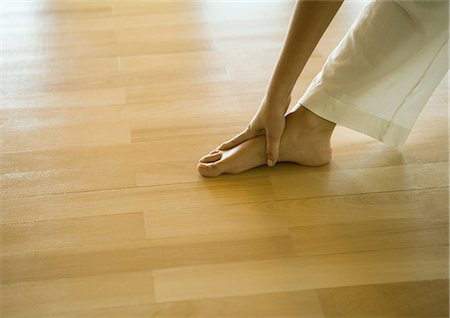 Woman doing standing forward bend, cropped view of hands and feet Stock Photo - Premium Royalty-Free, Code: 633-01572676