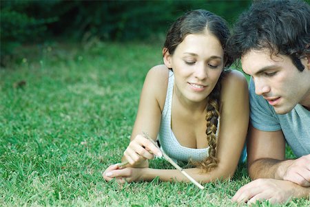 simsearch:633-01715612,k - Couple lying in grass, woman holding twig Stock Photo - Premium Royalty-Free, Code: 633-01573139