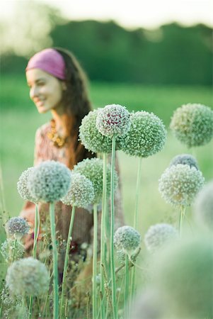 simsearch:633-01574151,k - Young woman, focus on allium flowers in foreground Stock Photo - Premium Royalty-Free, Code: 633-01573278