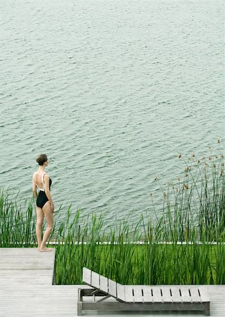 simsearch:633-01574151,k - Woman in swimsuit standing on deck, looking towards body of water Stock Photo - Premium Royalty-Free, Code: 633-01573956