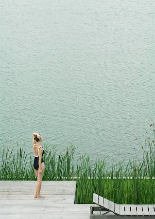 simsearch:633-01574151,k - Woman in swimsuit standing on deck, looking towards body of water Stock Photo - Premium Royalty-Free, Code: 633-01573951