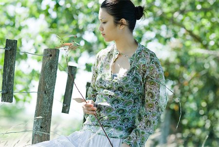 simsearch:633-01574151,k - Young woman holding branch in rural setting Stock Photo - Premium Royalty-Free, Code: 633-01714186