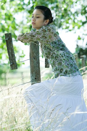 simsearch:633-01574151,k - Young woman leaning against rural fence, looking away Stock Photo - Premium Royalty-Free, Code: 633-01714182