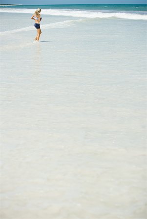 simsearch:633-01715682,k - Young woman jogging in surf, in mid-distance Stock Photo - Premium Royalty-Free, Code: 633-01714378