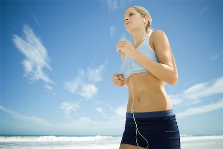 simsearch:633-01715682,k - Young woman jogging on beach, listening to MP3 player, low angle view Stock Photo - Premium Royalty-Free, Code: 633-01714388