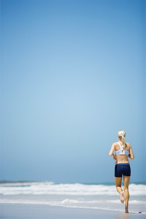 simsearch:633-01714467,k - Young woman jogging on beach, rear view, full length Stock Photo - Premium Royalty-Free, Code: 633-01714380