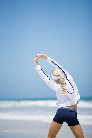 simsearch:633-01715682,k - Young woman in active wear stretching on beach, rear view Stock Photo - Premium Royalty-Free, Code: 633-01714396