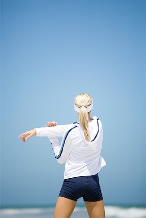 simsearch:633-01715682,k - Young woman in active wear stretching on beach, rear view Stock Photo - Premium Royalty-Free, Code: 633-01714397