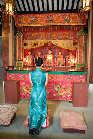 Young woman wearing traditional Chinese clothing, kneeling in front of shrine Stock Photo - Premium Royalty-Free, Code: 633-01714669