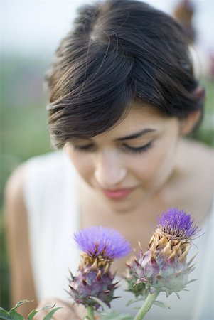 Young woman smelling thistle flowers Stock Photo - Premium Royalty-Free, Code: 633-01715094