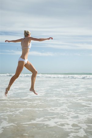 simsearch:633-01714467,k - Young woman in bikini, leaping in surf Stock Photo - Premium Royalty-Free, Code: 633-01715667