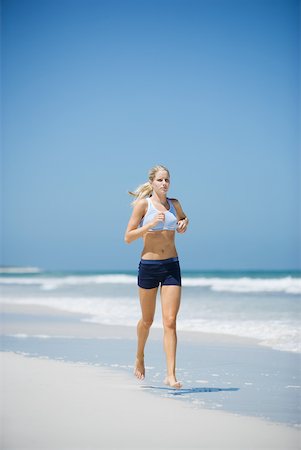 simsearch:633-01715682,k - Young woman running on beach, front view Stock Photo - Premium Royalty-Free, Code: 633-01715669