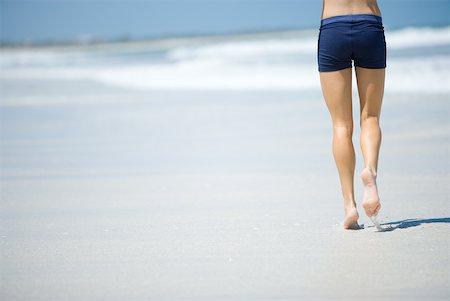 simsearch:633-01715682,k - Young woman running on beach, waist down, rear view Stock Photo - Premium Royalty-Free, Code: 633-01715682