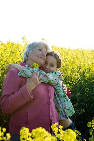 simsearch:632-01156716,k - Grand-mère hugging jeune fille, debout dans le champ de canola en fleurs Photographie de stock - Premium Libres de Droits, Code: 633-01715832