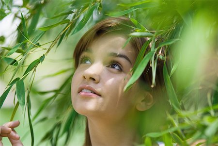 simsearch:633-01574151,k - Young woman standing in foliage, looking up, close-up Stock Photo - Premium Royalty-Free, Code: 633-01715860