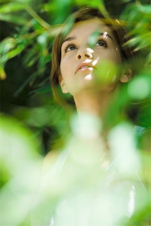 simsearch:633-01574151,k - Young woman standing in thick foliage, looking up Stock Photo - Premium Royalty-Free, Code: 633-01715886