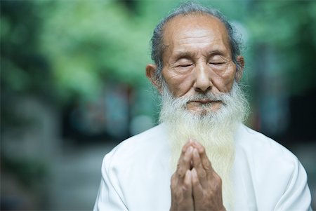 Elderly man in traditional Chinese clothing, hands clasped in prayer Stock Photo - Premium Royalty-Free, Code: 633-01715907