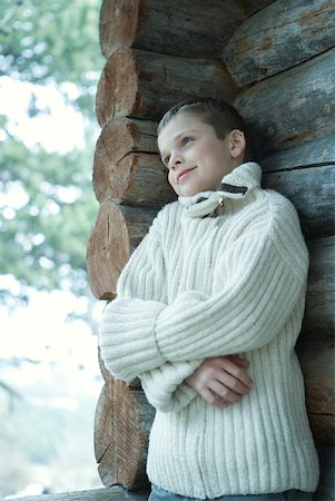 simsearch:695-03376367,k - Boy wearing wool sweater, arms folded, leaning against log cabin Stock Photo - Premium Royalty-Free, Code: 633-01713696