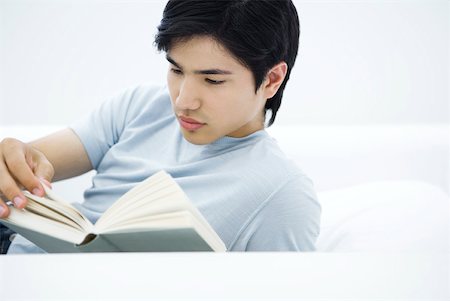 simsearch:632-03083700,k - Young man reading book, turning page Stock Photo - Premium Royalty-Free, Code: 633-02128675