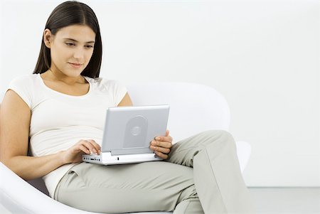 simsearch:649-07279862,k - Woman watching portable DVD player, sitting in chair Stock Photo - Premium Royalty-Free, Code: 633-02345870