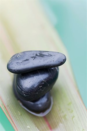 stacked stone - Wet stones stacked on palm leaf, close-up Stock Photo - Premium Royalty-Free, Code: 633-02417772