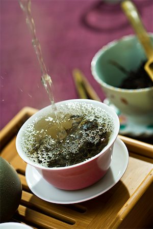 Hot water being poured and splashing over tea leaves in tea cup Stock Photo - Premium Royalty-Free, Code: 633-02417825