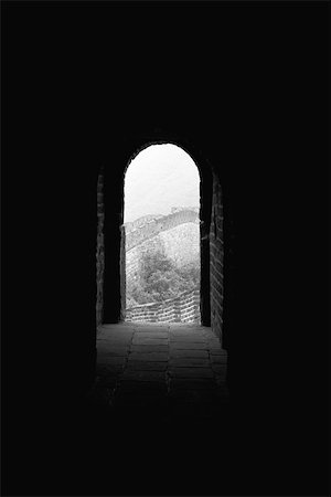 Looking down dark passageway to open arched doorway of room perched atop Great Wall of China Stock Photo - Premium Royalty-Free, Code: 633-02645301