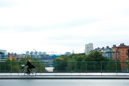 riding bike with basket - Sweden, Stockholm, bicyclist riding across bridge Stock Photo - Premium Royalty-Free, Code: 633-02691339