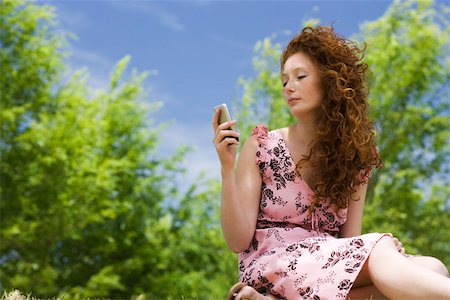 Young woman text messaging outdoors Stock Photo - Premium Royalty-Free, Code: 633-03444651
