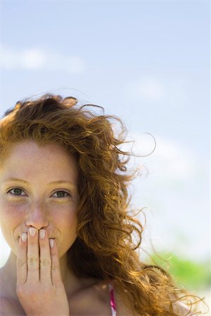 embarrassed women - Young woman covering mouth with hand, portrait Stock Photo - Premium Royalty-Free, Code: 633-03444667