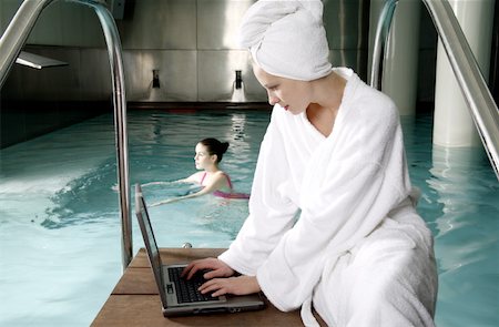 Woman on computer next  to a swimming pool Foto de stock - Sin royalties Premium, Código: 644-01435723