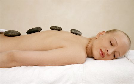 Young woman enjoying a hot  stone massage Foto de stock - Sin royalties Premium, Código: 644-01435747
