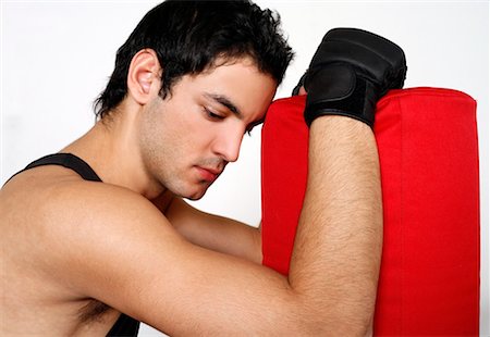 student fighting - Young man leaning on punching bag Stock Photo - Premium Royalty-Free, Code: 644-01436968