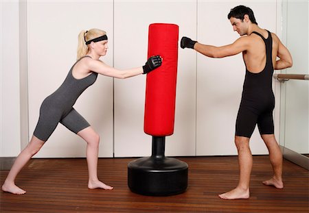 student fighting - Young man and woman practicing with a punching bag Stock Photo - Premium Royalty-Free, Code: 644-01436971