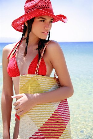 Young woman with bikini, hat, and beach bag Stock Photo - Premium Royalty-Free, Code: 644-01437523