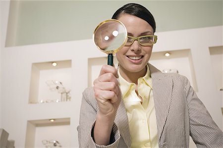 Woman with magnifying glass in store Stock Photo - Premium Royalty-Free, Code: 644-01630982