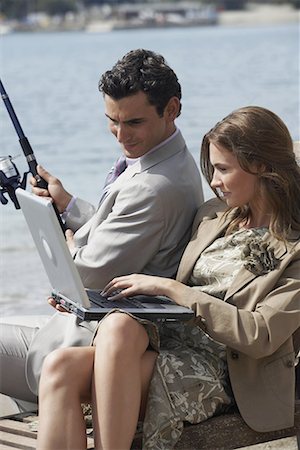 Business couple on beach with fishing rod and laptop Stock Photo - Premium Royalty-Free, Code: 644-01631107