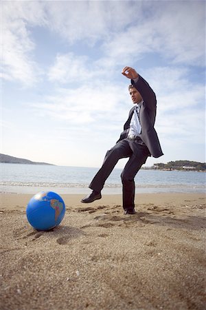 Businessman on beach with globe beach ball Stock Photo - Premium Royalty-Free, Code: 644-01631145