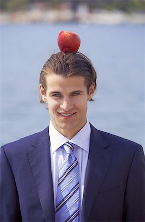 Businessman with apple balanced on his head Stock Photo - Premium Royalty-Free, Code: 644-01631156