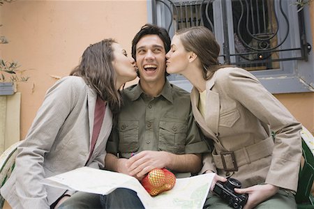 Homme sur banc étant embrassé par deux femmes Photographie de stock - Premium Libres de Droits, Code: 644-01631331