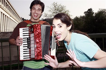 Man playing accordion, woman posing Stock Photo - Premium Royalty-Free, Code: 644-01631413