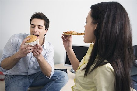 Male and female office workers eating take out food Stock Photo - Premium Royalty-Free, Code: 644-01825248